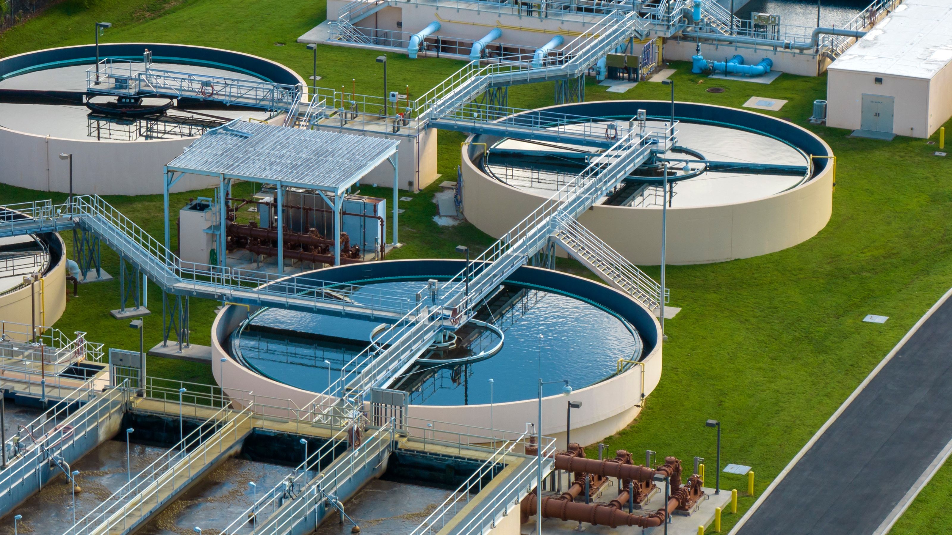 Vista aérea de una planta de tratamiento de agua con clarificadores circulares y balsas de proceso