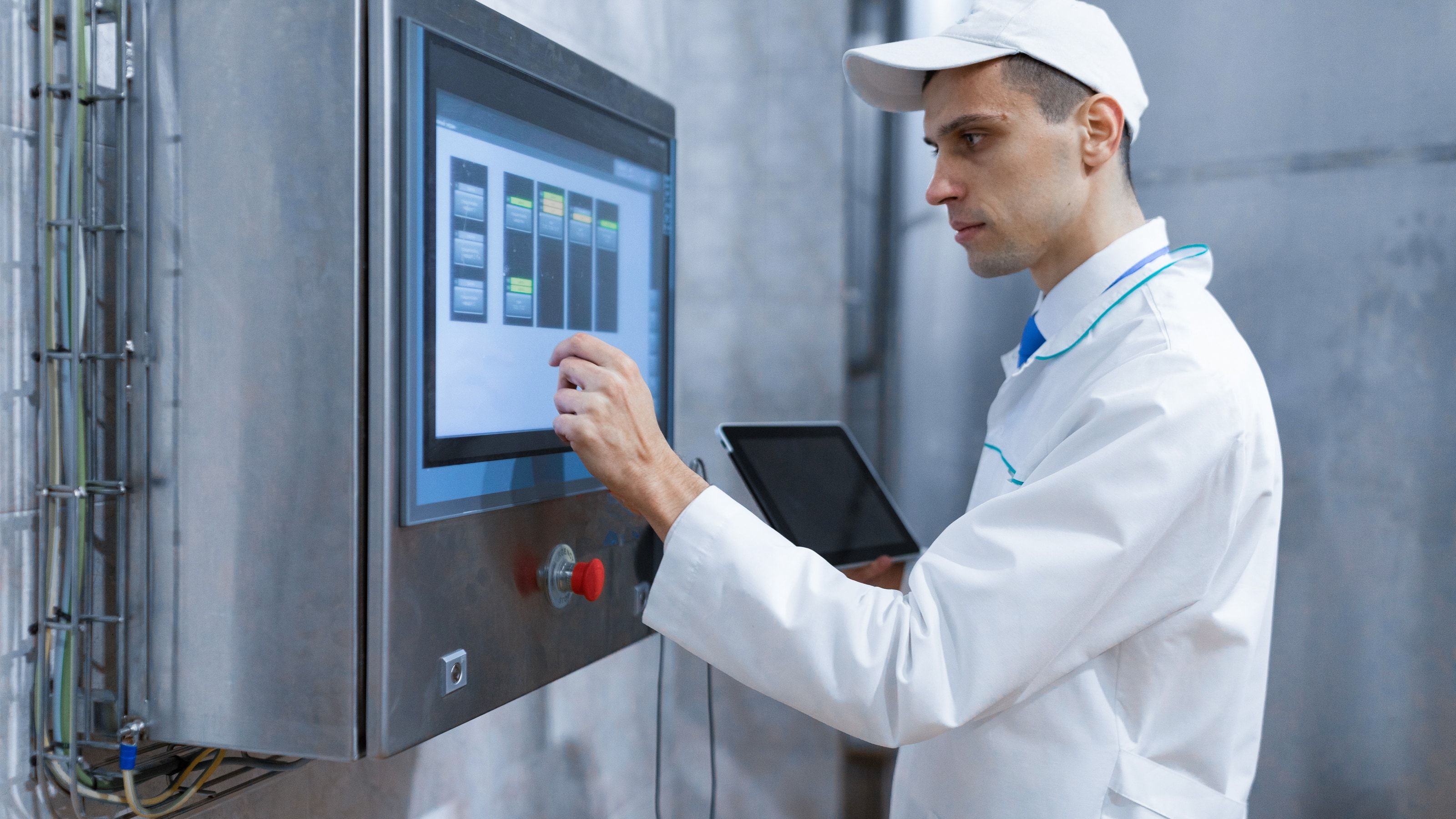 Técnico configurando una línea de producción frente a una pantalla de control