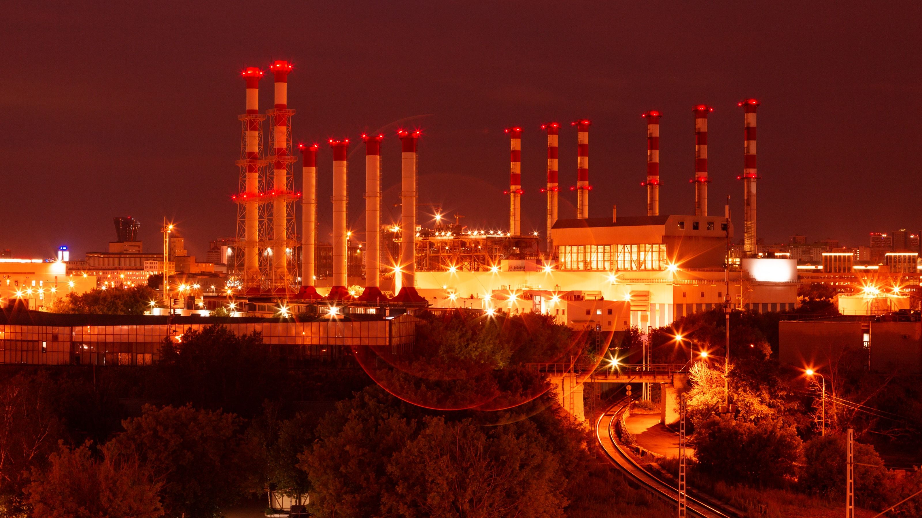 Planta petroquímica industrial iluminada al anochecer