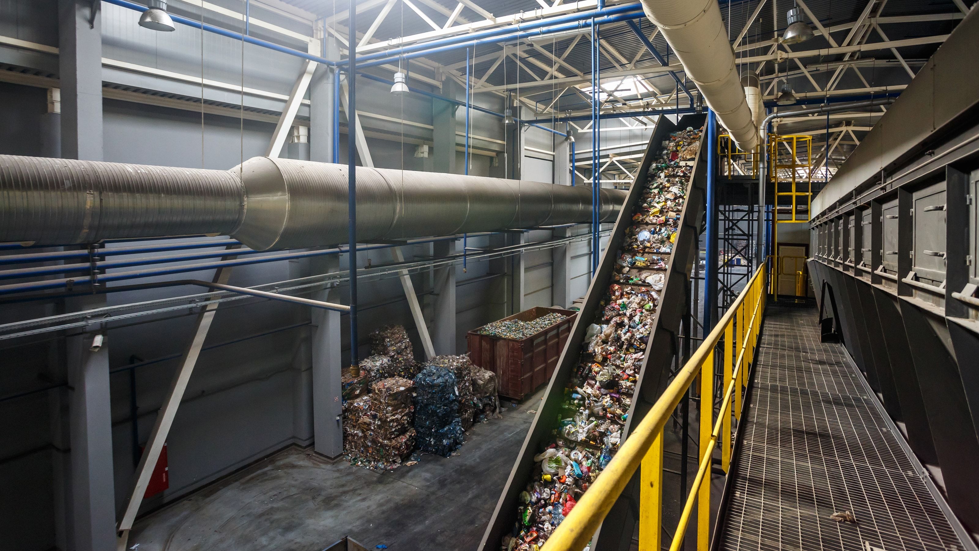 Planta de reciclaje de residuos con cinta transportadora inclinada y materiales clasificados