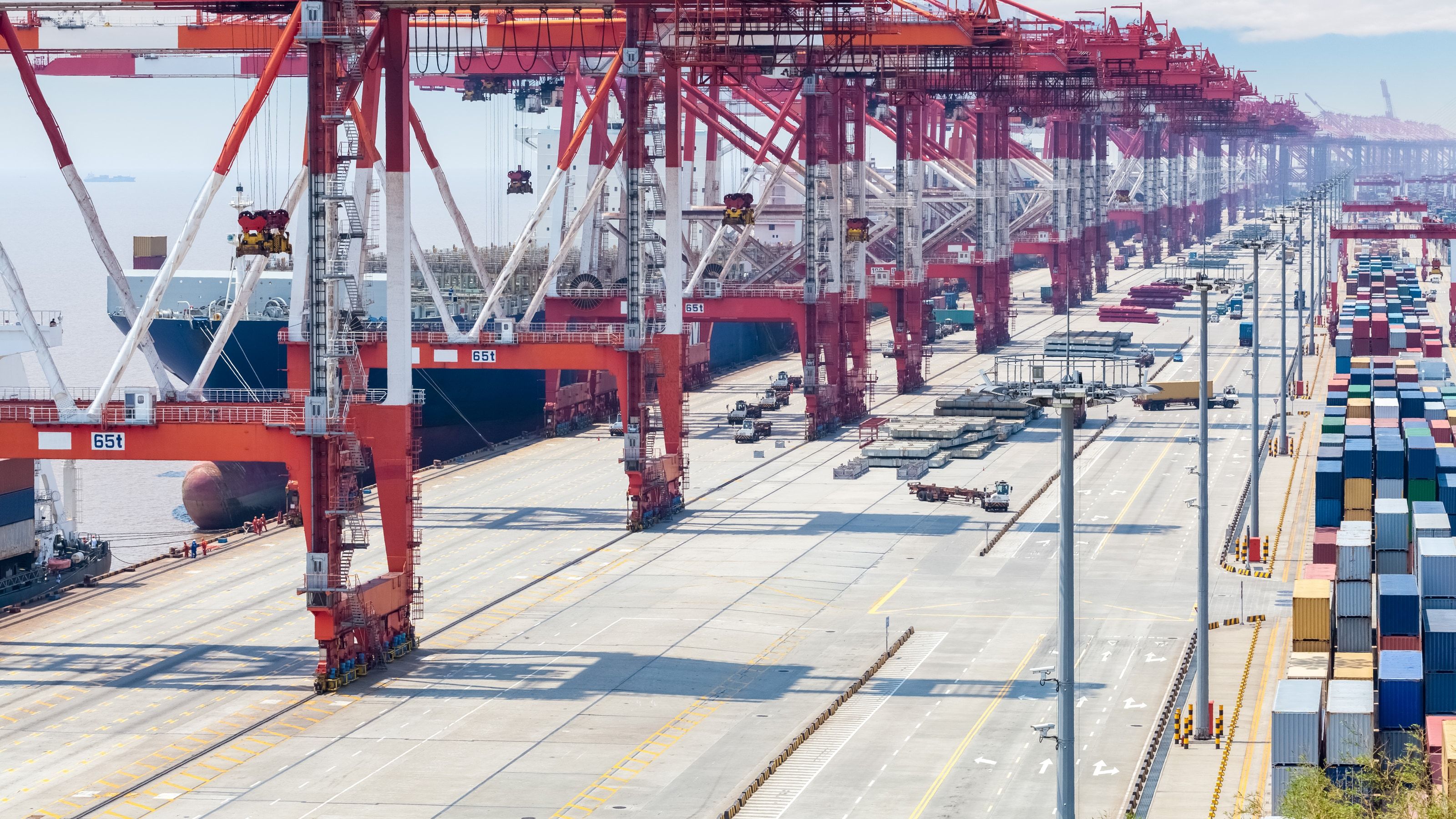 Terminal portuaria de contenedores con grúas pórtico y buques de carga